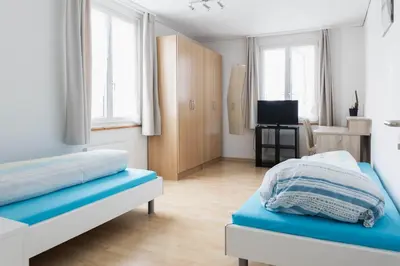 a bedroom with two beds and a television in it at Landgasthof Adler in 9304 Bernhardzell in Häggenschwil