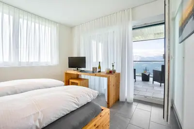 two beds in a bedroom with a view of the ocean at Hotel Restaurant Berghaus Malbun Buchserberg in Buchs
