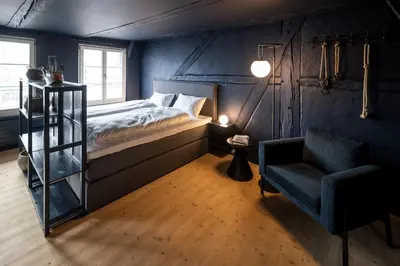 a bedroom with a bed and a chair at JACOB 1808. fine historic town apartments in Bischofszell
