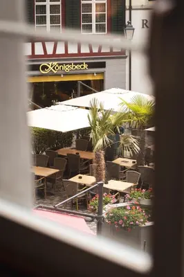 a view from a window of a restaurant with tables and umbrellas at JACOB 1808. fine historic town apartments in Bischofszell