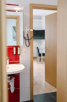 a bathroom with a sink and a mirror at Hotel & Restaurant Nollen in Hosenruck
